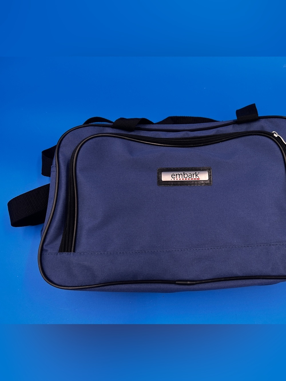 This is a blue Embark brand messenger bag or carry on